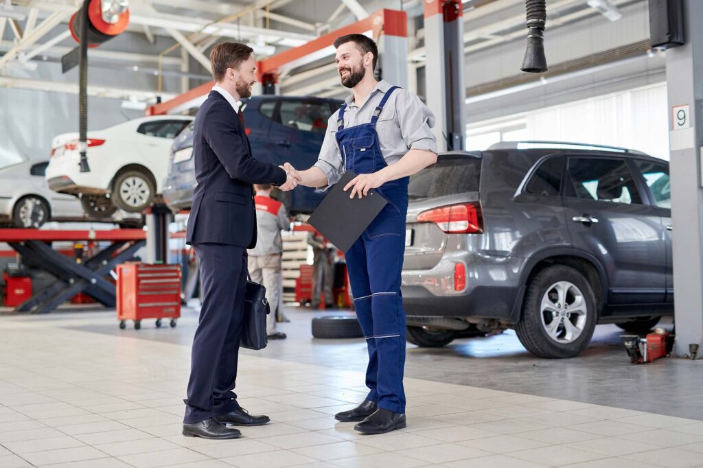 Mecanico dando la mano a cliente